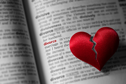 Red broken heart on dictionary divorce definition. The concept of divorce, parting, infidelity . Selective focus.