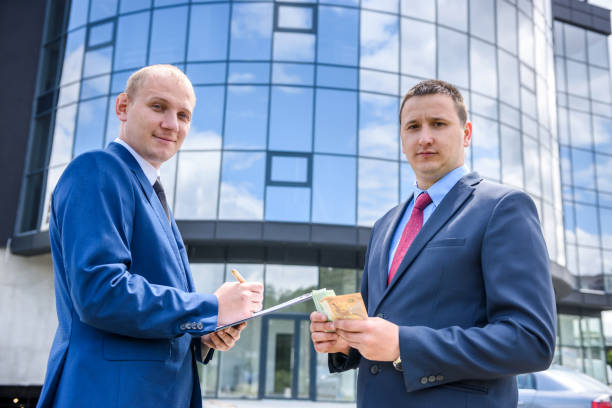 istock Two men in suit making deal outdoors 1202437982