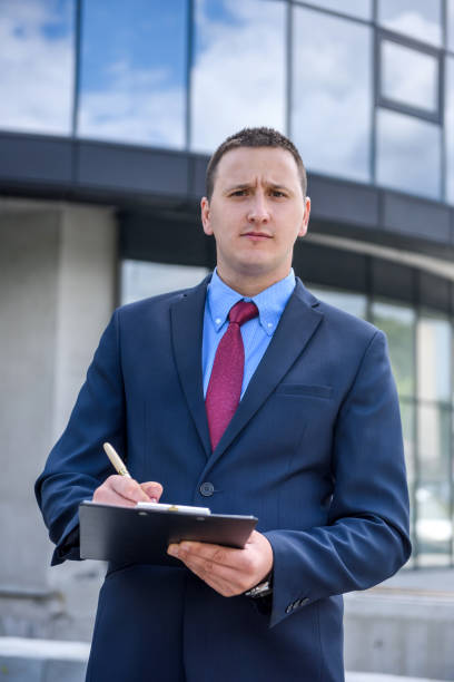 istock Agent posing with clipboard against new house 1202438080