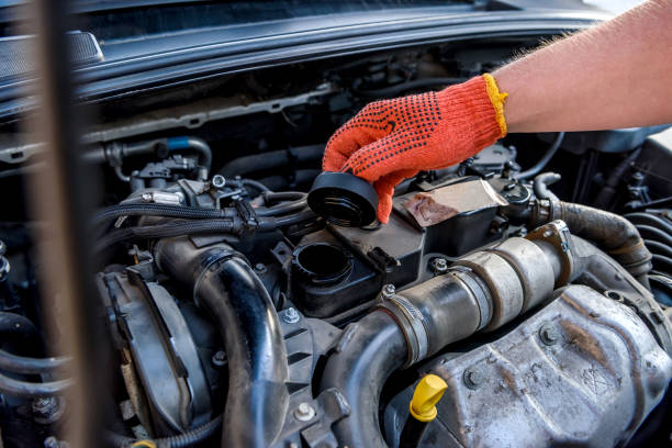 istock Hands of mechanic's in protective gloves with car engine close up 1202438261