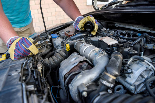 istock Hands of mechanic's in protective gloves with car engine close up 1202438284
