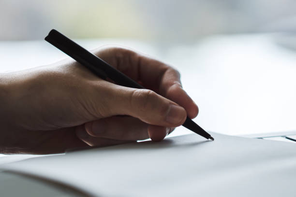 istock Man writing in notepad. Close up. Focused on a hand with pen 1202440464