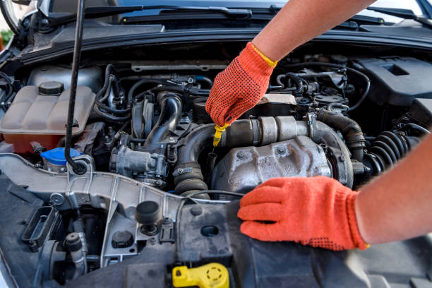 istock Hands of mechanic's in protective gloves with car engine close up 1202440502