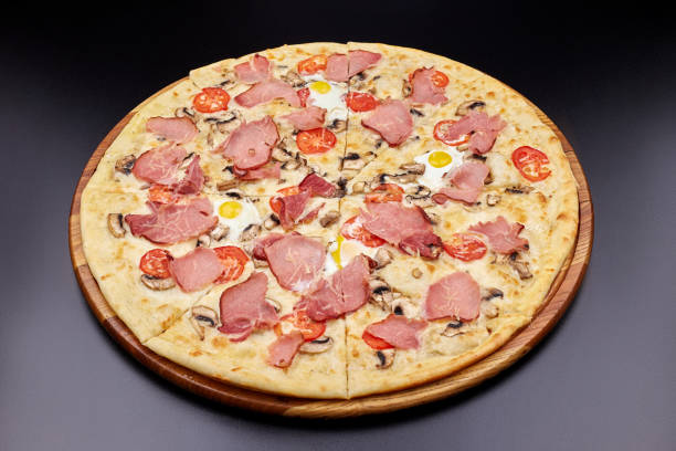 istock Carbonara pizza with bacon and egg on beautiful grey table. Isolated on dark background. 1202442713
