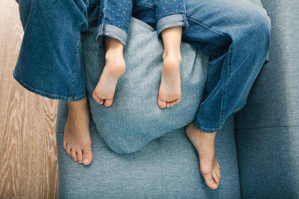 pies de mujer adulta y tacones de niño vista superior - child human foot barefoot jeans fotografías e imágenes de stock