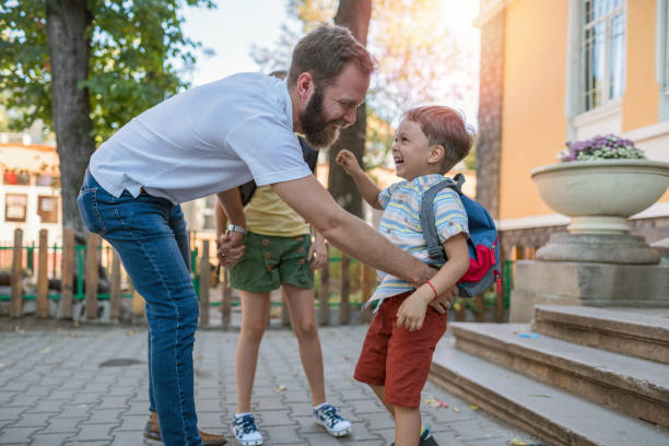 istock Father hugging his kids in the schoolyard 1202445570