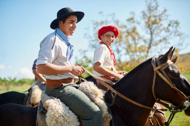 Young gauchos riding their horse traditionally dressed.