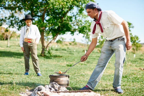 istock A gaucho young man frying empanadas in the embers. 1202445604