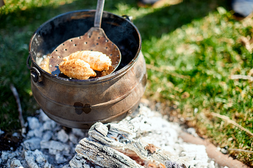 Gaucho simple lifestyle scenes. Shot with a real family in Cordoba Argentina.
Close up view of a pot with frying empanadas on fire ember.