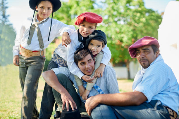 istock Brothers sitting in the grass during and Argentinian barbecue. 1202445666