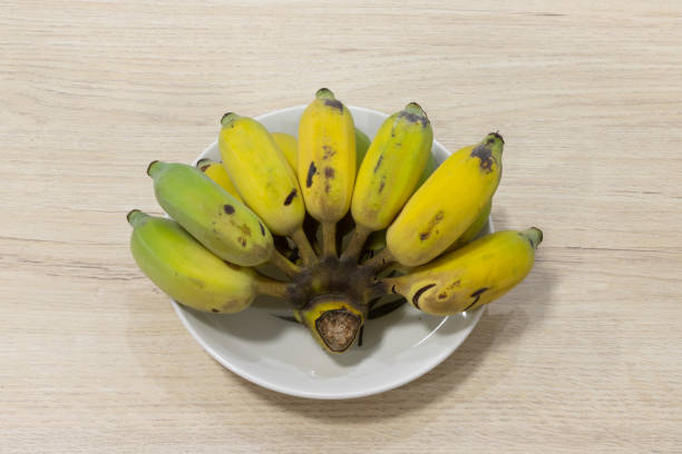 istock Banana in dish white on table wood. 1202445758