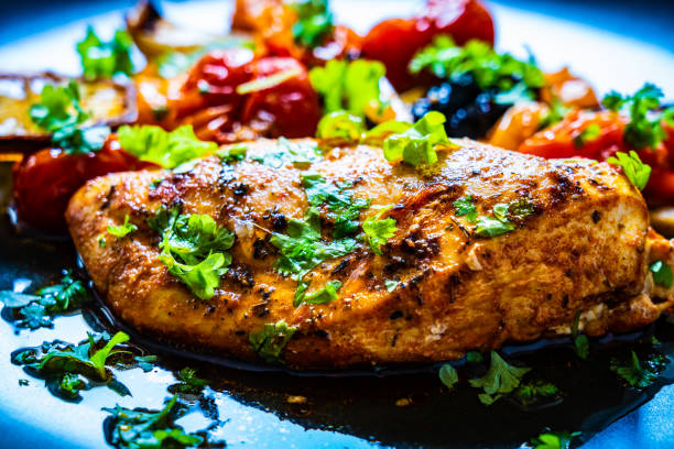 istock Fried chicken breast and vegetables on black plate 1202446787