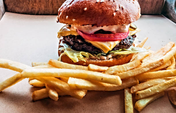 istock Hamburger and fried potatoes wooden table background 1202447222