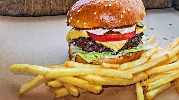 istock Hamburger and fried potatoes wooden table background 1202447760