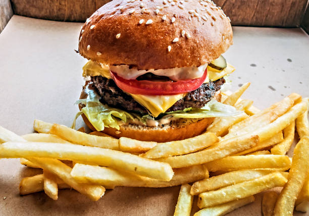 istock Hamburger and fried potatoes wooden table background 1202448269