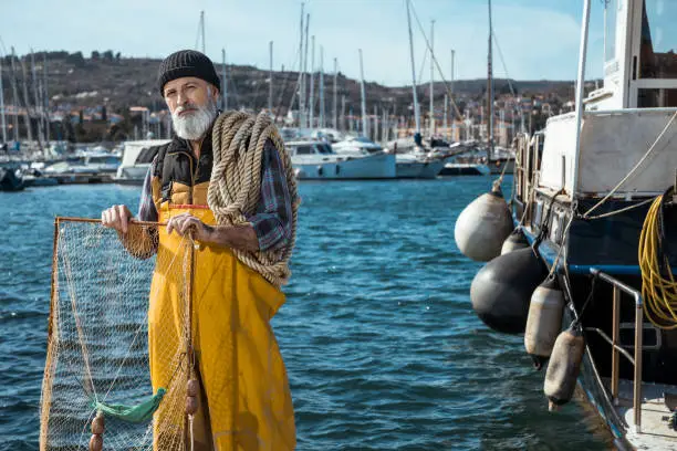 Portrait of senior fisherman in front of sea
