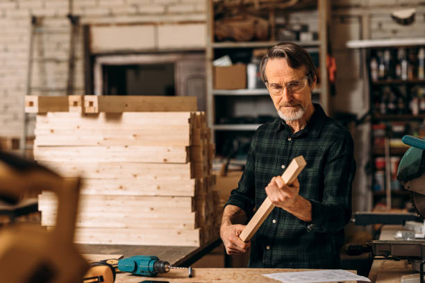 istock Carpenter checking wood part for straightness while preparing for furniture 1202450235