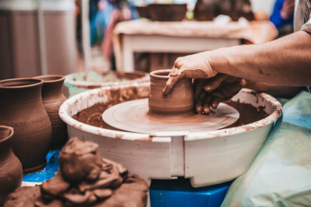 istock Working with clay on a potter's wheel - craftsman 1202450584