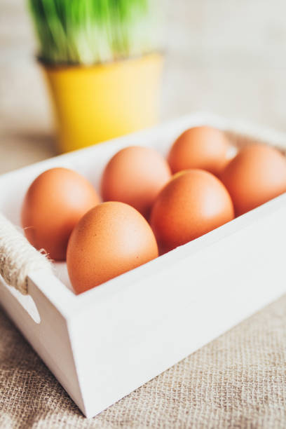 Close-up of a box of raw eggs on a white wooden table