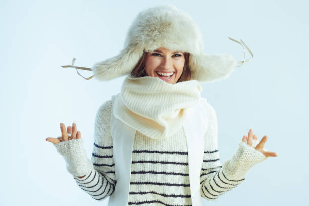 istock smiling young woman jumping on winter light blue background 1202456130