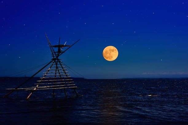 Full moon rising over the Bora-machi-yagura (Fishing Turret)  and peninsula.A fisherman climbs the tower, and waits to come, and lifts the net. It is a old fishing method.