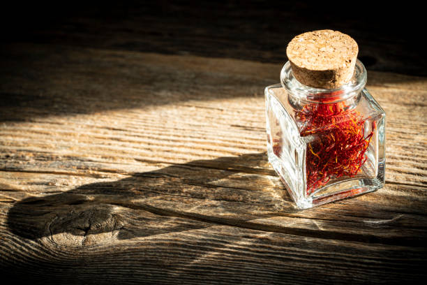 istock Saffron spice in glass bottle on rustic wooden table 1202460403