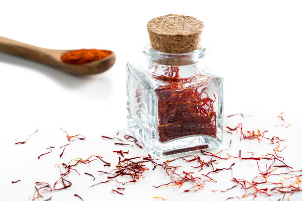 istock Saffron spice in glass bottle isolated on white 1202460429