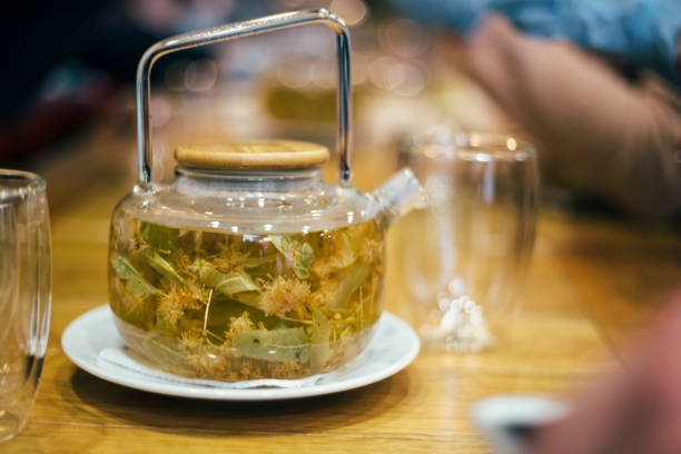 istock Teapot with linden tea and flowers 1202461837
