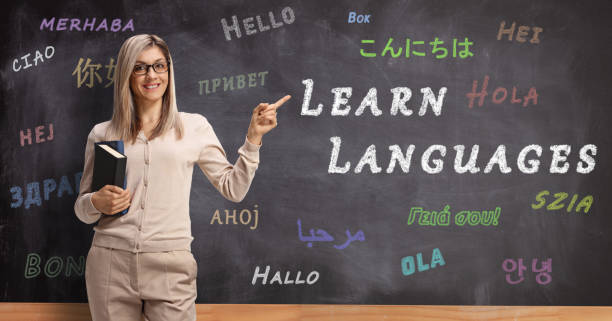 istock Female language teacher pointing to a blackboard with text learn languages 1202462111