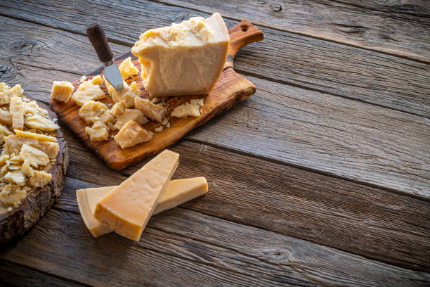 Parmesan Reggiano cheese on cutting board and knife at wooden table