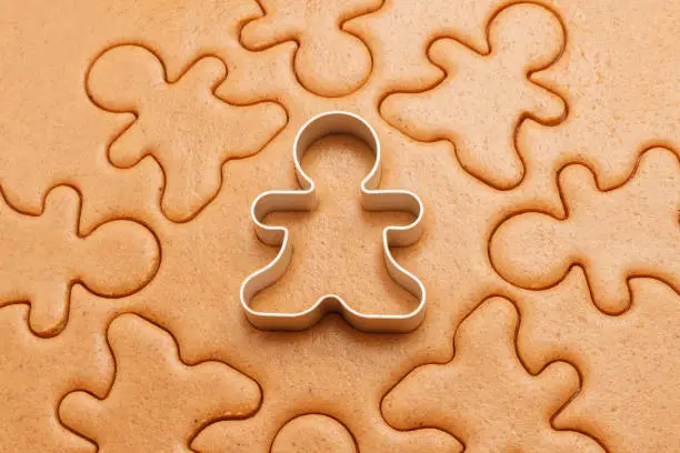 Gingerbread men background. Christmas baking texture with cutter