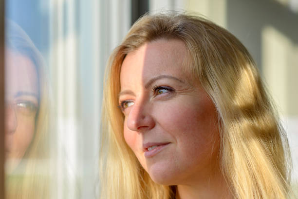 istock Attractive blond woman standing daydreaming 1202464608