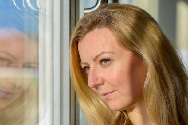istock Attractive blond woman standing daydreaming 1202464933