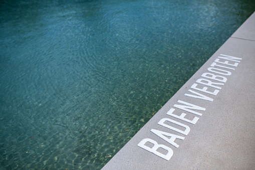 Germany: Close up of the word 'bathing forbidden' at the swimming pool.