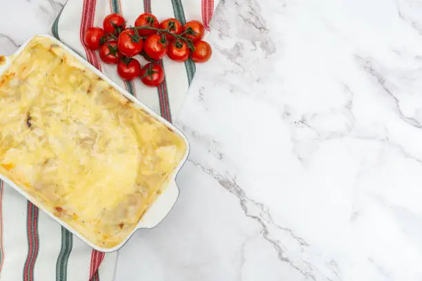 Photo of Traditional Italian lasagna with minced beef Bolognese sauce served in oven plate with copy space for your text