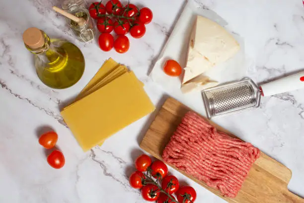 Photo of Flat lay view of raw ingredient for cooking Italian Bolognese lasagna