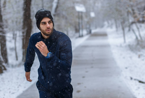 istock Young man running in city park at cold winter day. 1202468037