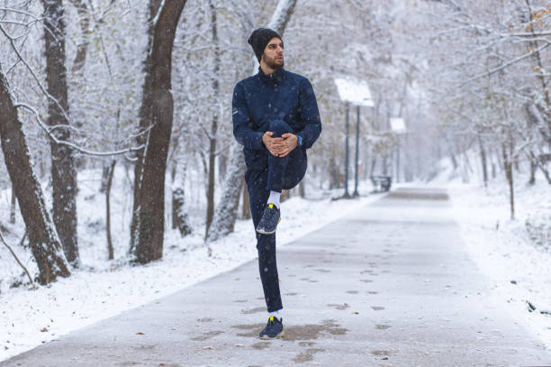 istock Young man stretching before running in city park at cold winter day. 1202468607