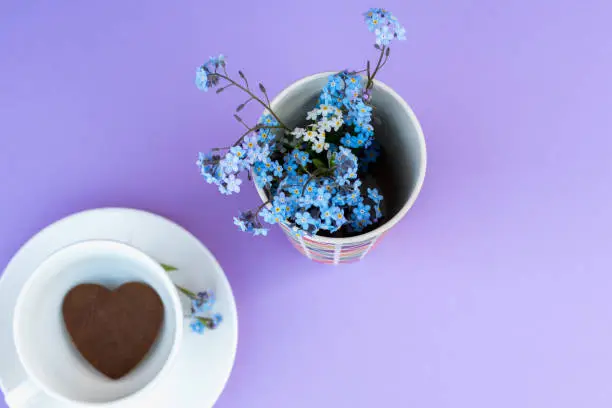 Coffee mug on a purple background. background Breakfast, drinks and cafe menu concept - coffee cup on purple background, toplay flatlay. cookies to coffee. White mug. copy space.