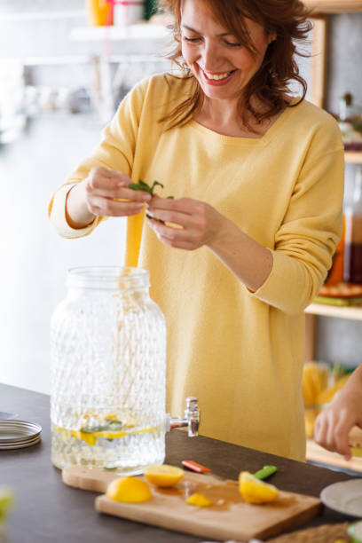 istock Woman adding aromatic herbs to a juice 1202469244