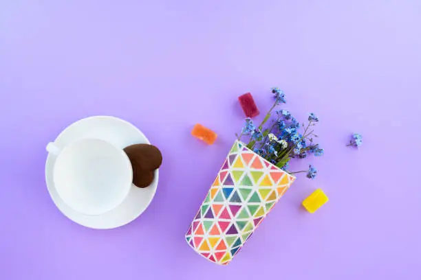 Coffee mug on a purple background. background Breakfast, drinks and cafe menu concept - coffee cup on purple background, toplay flatlay. cookies to coffee. White mug. copy space.