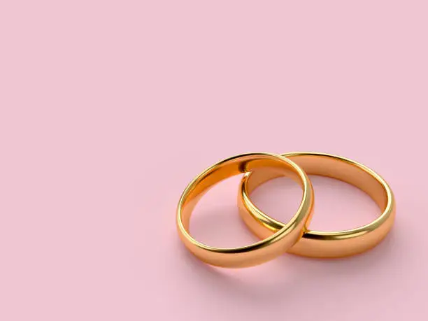 Two wedding gold rings lie on each other with blank space for text. 3d rendering