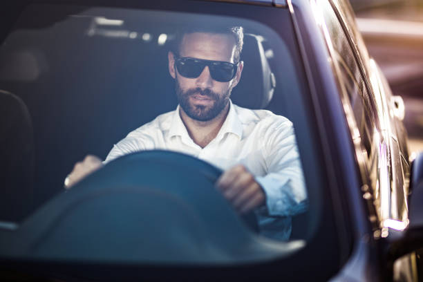 Young businessman going on business travel by car. The view is through windshield.