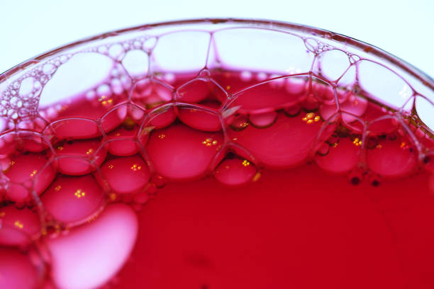 Micro Bubbles Clusters backlit with a white light. Micro Bubbles in a Pink and red  liquid. Close up taken with a Macro lens in the studio.