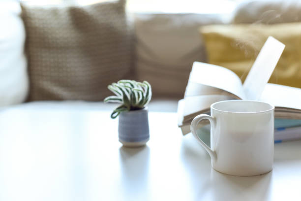 istock Relaxing sofa area with coffee table and hot drink in modern home interior 1202471097