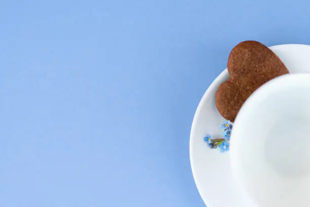 Mug of coffee on a blue background. background Breakfast, drinks and cafe menu concept - coffee cup on purple background, toplay flatlay. cookies to coffee. White mug. copy space.