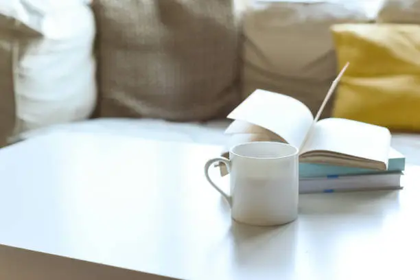 Photo of Relaxing sofa area with coffee table and hot drink in modern home interior