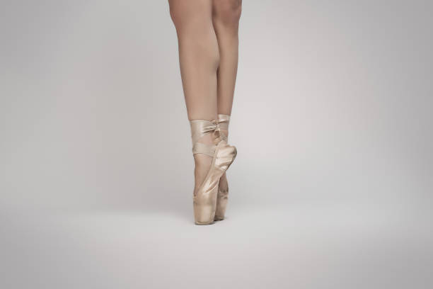 istock Ballerina dancing en pointe against a white background, Low section 1202475346