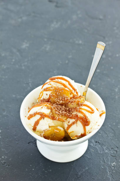 istock vanilla ice cream with bananas and caramel in a bowl. 1202475393