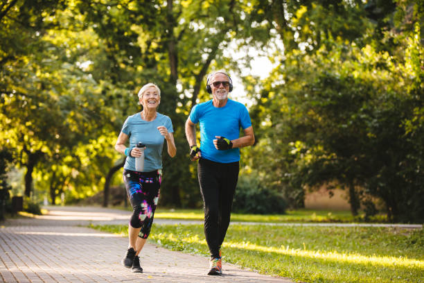 istock Senior couple jogging together in the park 1202475681